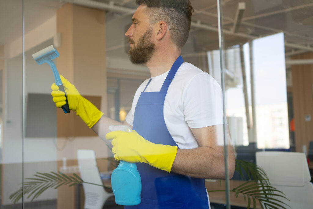 professional cleaning service person cleaning office window