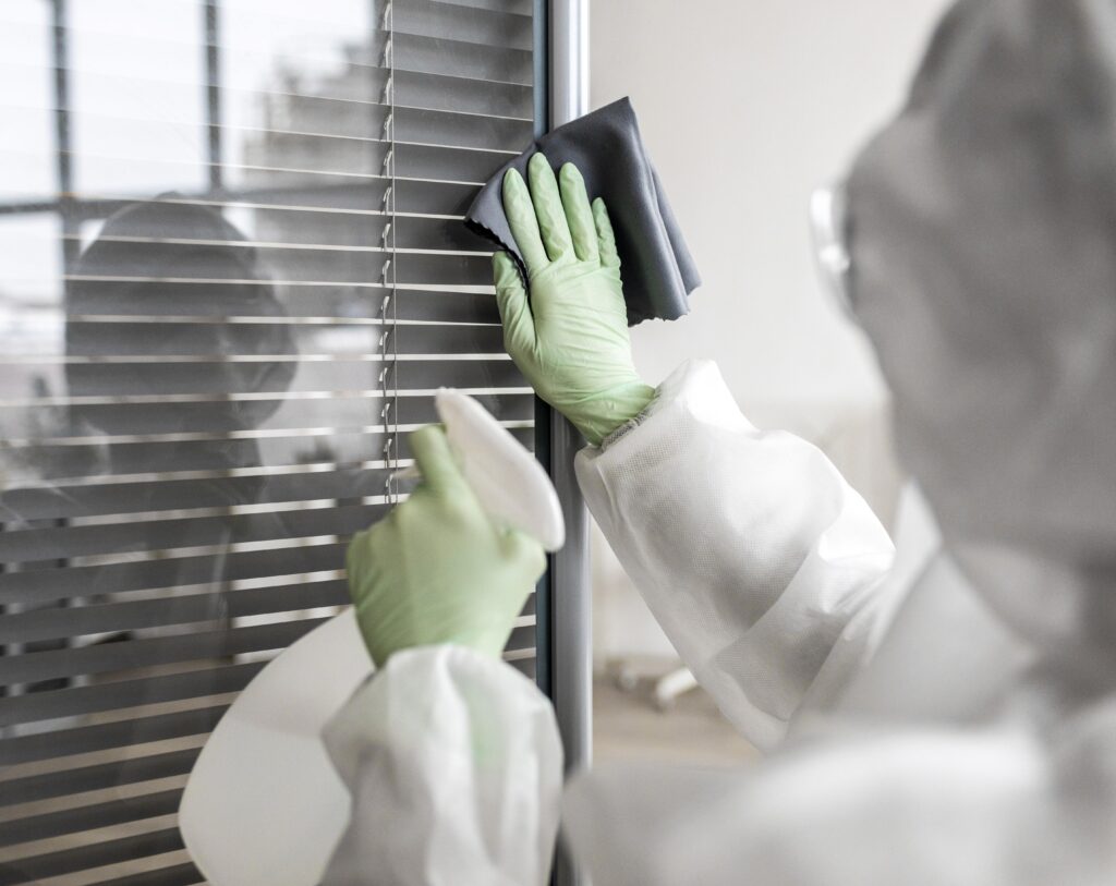 person disinfecting dangerous area while wearing protective suit